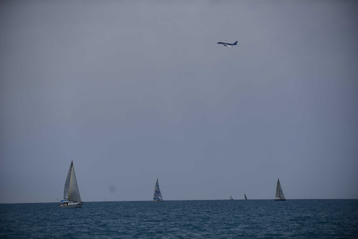 A plane flies above as Israelis take part in the Sail Tel-Aviv Yafo sea festival featuring various sea sports, on April 30, 2016. Photo by Tomer Neuberg/Flash90 *** Local Caption *** ????? ???? ???? ?????? ?? ??? ?? ?????? ?? ???? ???