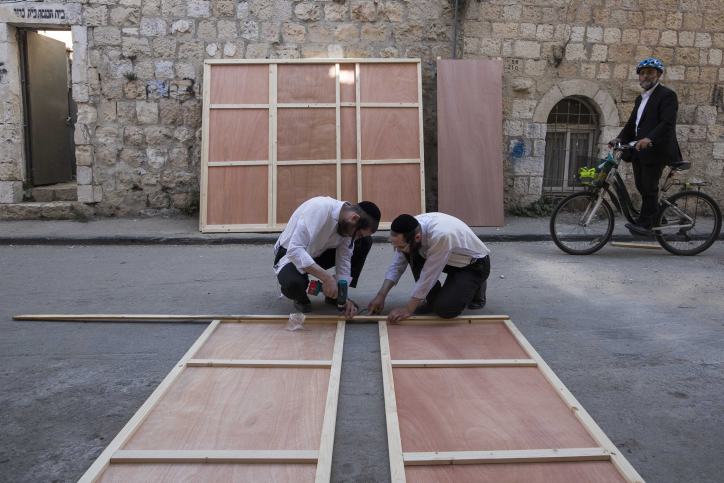 Ultra orthodox Jewish men build a "Sukka" for the upcoming Jewish holiday of Sukkot, in the streets of the ultra orthodox neighborhood of Meah Shearim in Jerusalem. October 10, 2016. Sukkot commemorates the Israelites 40 years of wandering in the desert and a decorated hut or tabernacle (sukka) is erected outside religious households as a sign of temporary shelter. Photo by Nati Shohat/Flash90 *** Local Caption *** ???? ????? ????? ??????? ????? ???? ????? ????? ????? ??? ?????