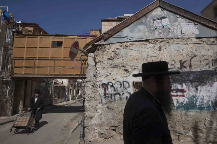 Ultra orthodox jews walk by a street full of "Sukkot" (temporary dwelling), in the religious neighborhood of Mea Shearim in Jerusalem on October 10, 2016. Sukkot commemorates the Israelites 40 years of wandering in the desert and a decorated hut or tabernacle (sukka) is erected outside religious households as a sign of temporary shelter. Photo by Nati Shohat/ FLASH90. *** Local Caption *** ???? ???? ????? ??? ????? ?????