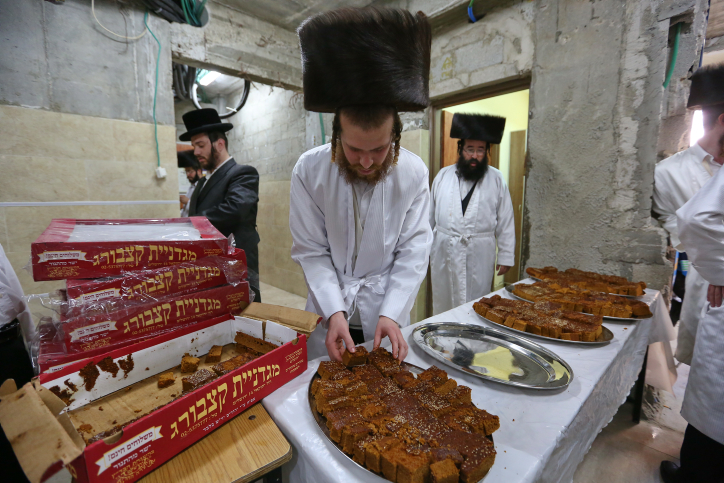 Ultra Orthodox Jewish men of the Hassidic Lelov dynasty eat honey cake, a few hours before the start of Yom Kippur, the Jewish holy day of Atonement, in a synagogue in the town of Bet Shemesh, outside of Jerusalem. Israel came to a standstill for 25-hours during the high holiday of Yom Kippur when observant Jews fast and Israelis are prohibited from driving October 11, 2016. Photo by Yaakov Lederman / FLASH90 *** Local Caption *** ??? ????? ??? ??? ??? ???? ????? ???? ????