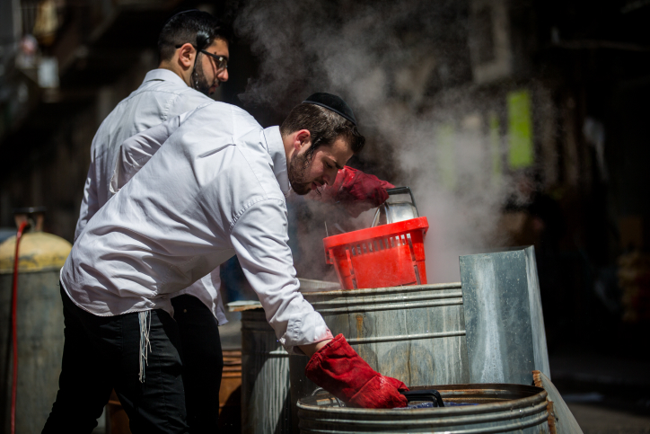 Ultra Orthodox Jewish men get their cooking pots dipped into hot water to rid any traces of leavening in preparation for the upcoming Passover holiday, in the ultra orthodox neighborhood of Meah shearim in Jerusalem on April 9, 2017. Photo by Yonatan Sindel/Flash 90 *** Local Caption *** ??? ??? ????? ???? ????? ????? ???? ????? ?????