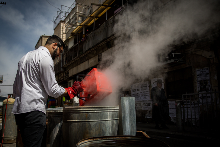 Ultra Orthodox Jewish men get their cooking pots dipped into hot water to rid any traces of leavening in preparation for the upcoming Passover holiday, in the ultra orthodox neighborhood of Meah shearim in Jerusalem on April 9, 2017. Photo by Yonatan Sindel/Flash 90 *** Local Caption *** ??? ??? ????? ???? ????? ????? ???? ????? ?????