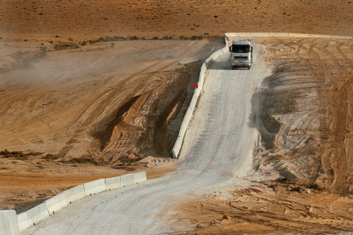 A truck drive along the separation barrier in the desert close to Har Hamassa area