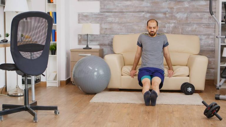fit-guy-training-triceps-sofa-home-wearing-sportswear
