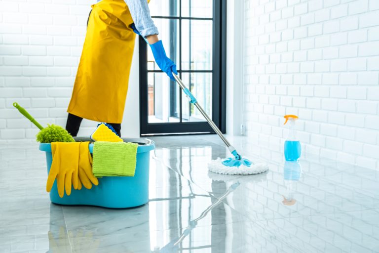 happy-young-woman-blue-rubber-using-mop-while-cleaning-floor-home
