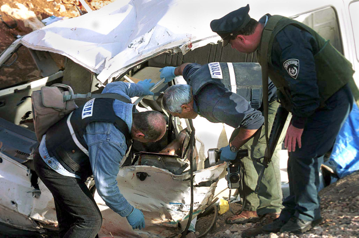 Israeli police inspect the remains of the van of Benjamin Kahane