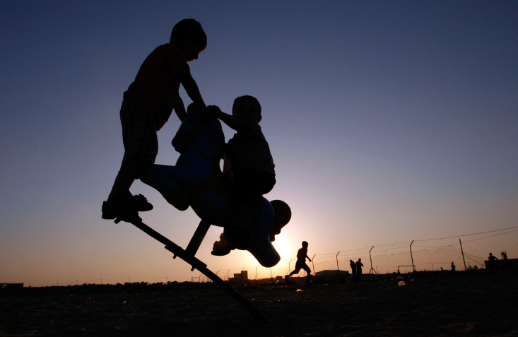 Palestinian children play at UN Cabarets the summer holidays a during sunset