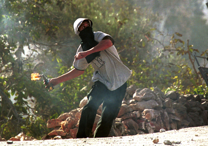 A Palestinian youth hurls a  molotov coctail