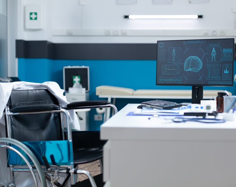 Empty modern hospital office room equipped with medical professional equipment