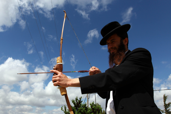 Ultra Orthodox Jew cuts the hair of three year old boy during the celebration of the Jewish holiday of Lag Baomer in Mt Meiron