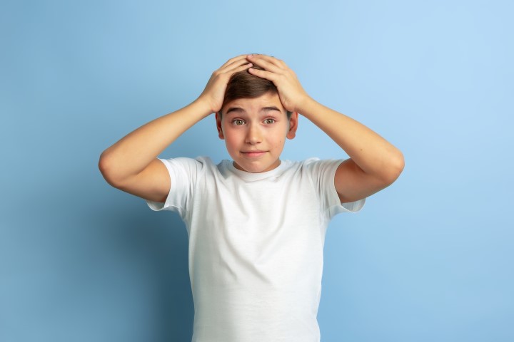 Caucasian teen's portrait isolated on blue studio background