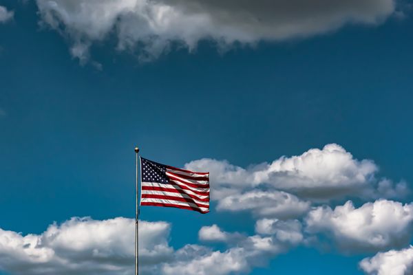 closeup-shot-american-flag-waving-air-cloudy-sky