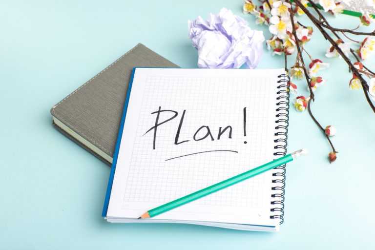 front-view-open-copybook-with-pencil-flowers-blue-surface