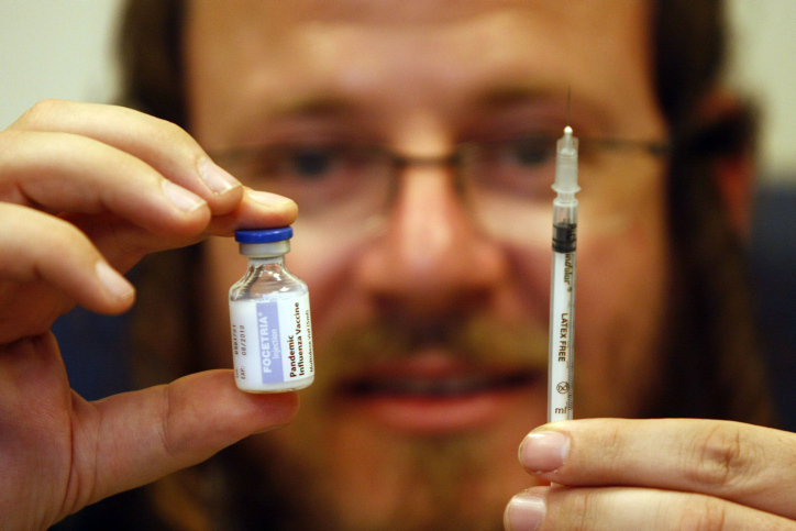 Israel Bookshpan holding a swine flu vaccine