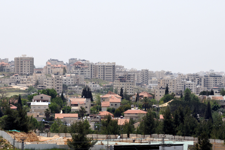 Residential buildings in the Jewiah settlement of Beit El, backdropped by the neighbouring Palestinian refugee camp of Jalazone