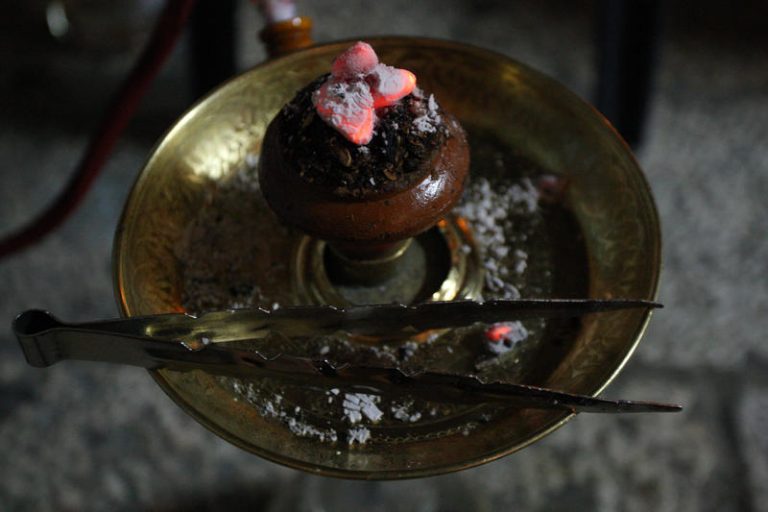 The embers burning bright on top of the hookah as its being smoked in the old city