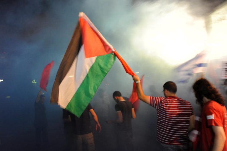 Smoke rises from a smoke granade that was thrown into the crowd during a demonstration in Tel Aviv