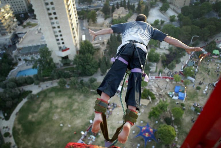 An Israeli men bungie jumps during the annual student day